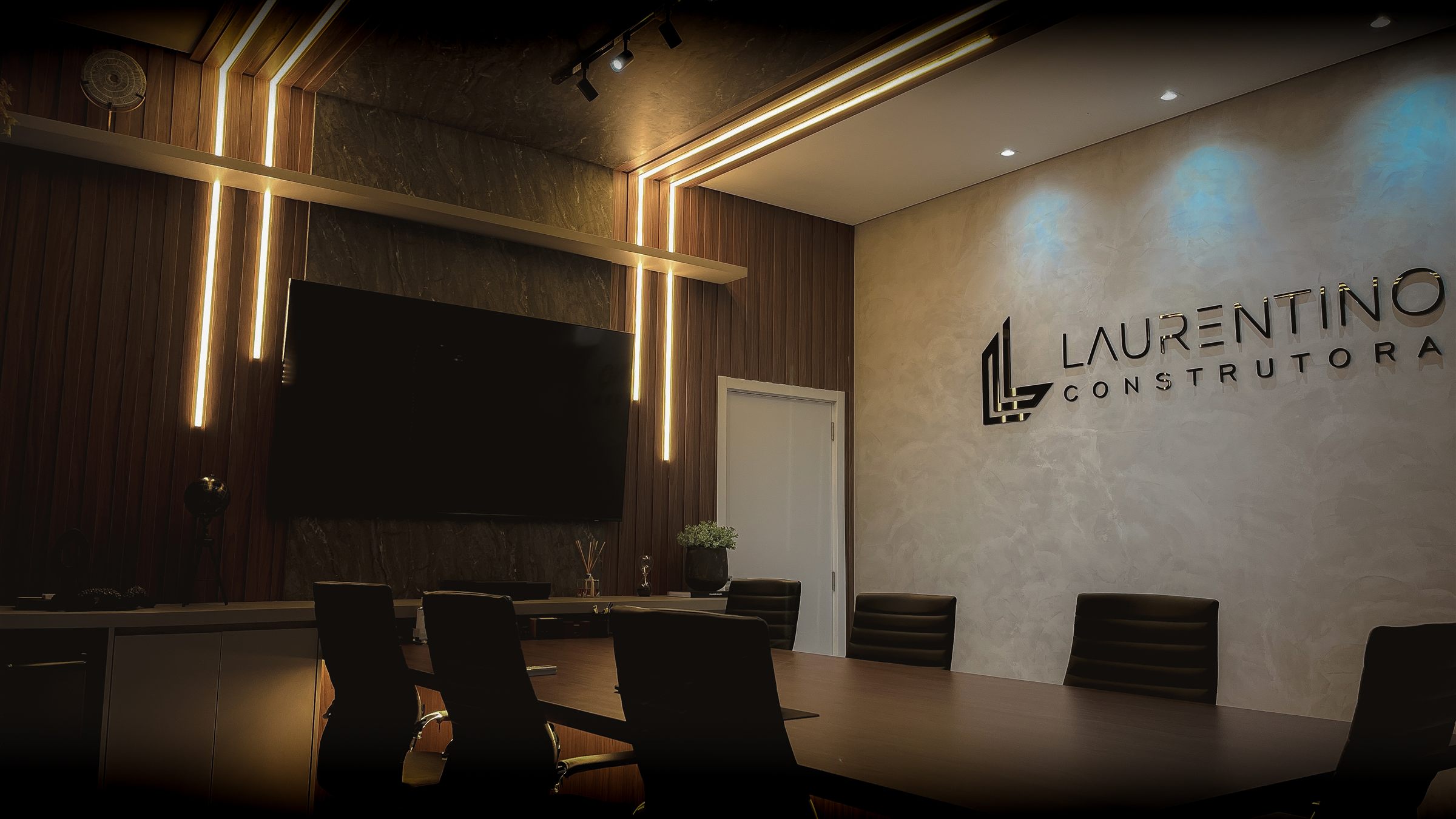 Sala de reuniões do escritório da Laurentino, com o logotipo na parede